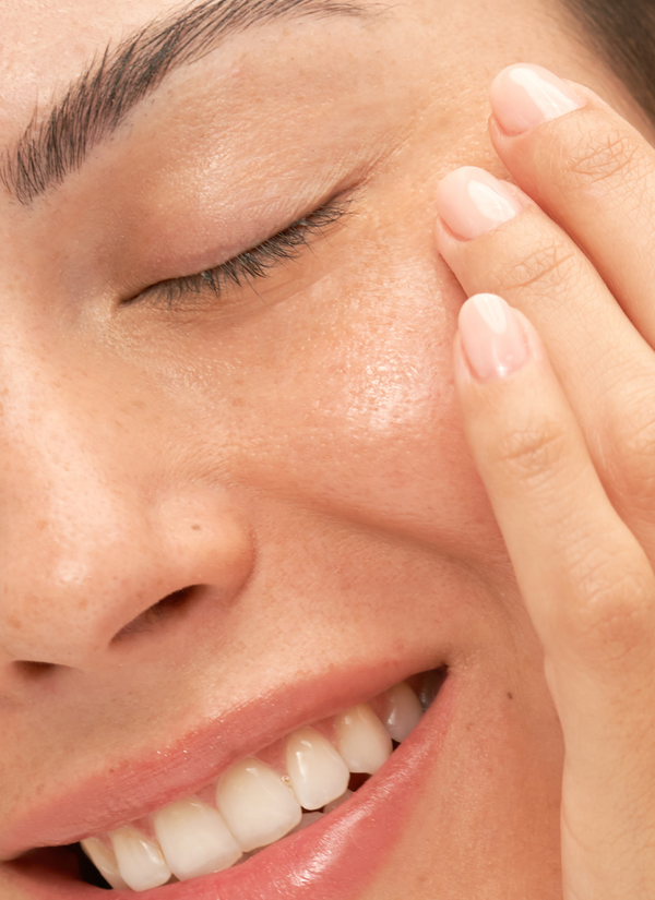 Woman rubbing Tightening Eye Gel product on cheek