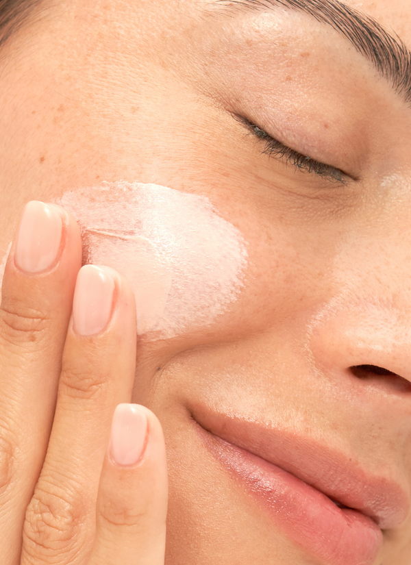 Woman rubbing Urban Antioxidant Sunscreen product on cheek